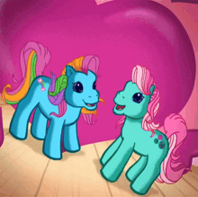 a couple of ponies standing next to each other in front of a purple heart