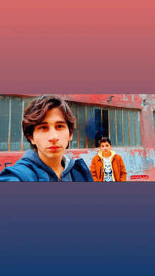 two young men pose for a picture in front of a red wall