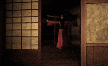 a person in a red robe is standing in a dark room