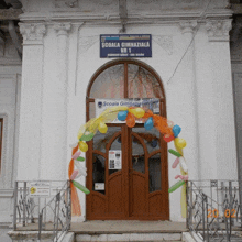 a school with balloons and a sign that says " scoala gimnaziala nr 1 "