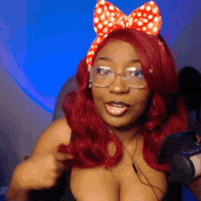 a woman with red hair and glasses is wearing a bow on her head
