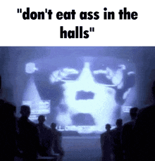 a group of people looking at a screen that says " don t eat ass in the halls "