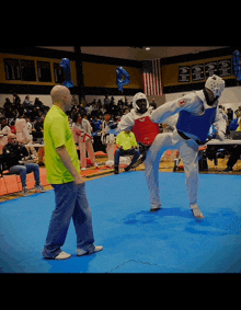 a man in a green shirt watches a martial arts tournament