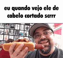 a man eating a hot dog with the caption eu quando veja ele de cabelo cortado scrr