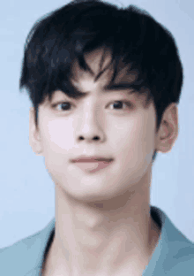 a close up of a young man 's face wearing a green shirt and looking at the camera .