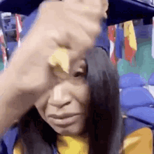 a woman in a graduation cap and gown is crying while holding a piece of bread in her hand .