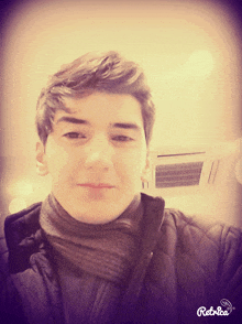 a young man wearing a scarf and a black jacket takes a selfie with the app retrea