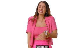 a woman in a pink shirt is crying with salonline written on the bottom right