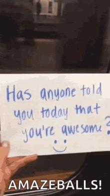 a person is holding a piece of paper that says `` has anyone told you today that you 're awesome ? ''