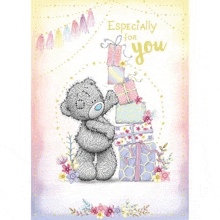 a teddy bear is standing next to a pile of gifts and flowers .