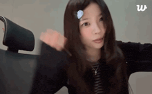 a woman with long hair is sitting in a chair with her arms outstretched and looking at the camera .