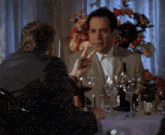a man sitting at a table with a bottle of wine in front of him