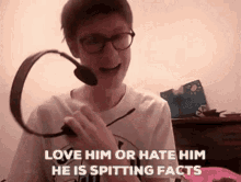 a man wearing glasses and headphones says love him or hate him he is spitting facts