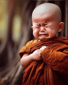 a baby with a bald head is crying with his eyes closed