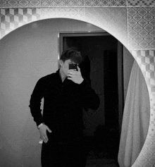 a man takes a selfie in front of a mirror