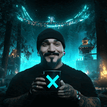 a man with a beard is holding a cup with a blue x on it