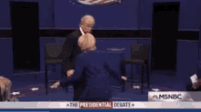 a man in a suit and tie is dancing with a woman in front of a sign that says the presidential debate