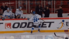 a hockey player with the number 24 on his jersey is skating on the ice