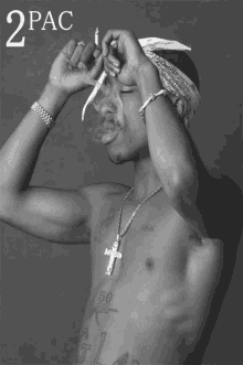 a shirtless man with a bandana on his head smoking a cigarette with the words 2pac above him