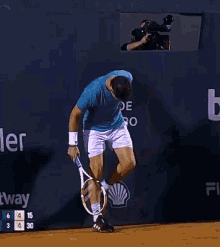 a man in a blue shirt and white shorts is playing tennis in front of a wall that says rio de janeiro