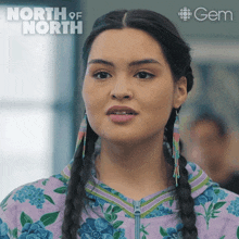 a woman is wearing a purple floral shirt with the word north of north on the bottom