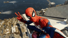 a man in a spiderman suit is sitting on top of a building