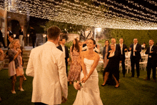 a bride and groom are dancing with their wedding guests