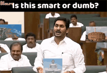 a man in a white shirt is holding a picture of a buddha in front of a group of people