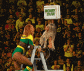 two women wrestling in front of a crowd with a box that says money bank