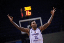 a basketball player wearing a number 35 jersey is raising his arms in the air