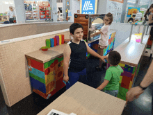 a boy in a black tank top is standing in front of a sign that says aldi