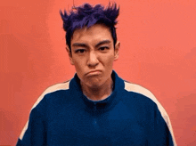 a man with purple hair is wearing a blue jacket and making a face .