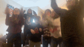 a group of people are dancing in front of a sign that says " the bible "