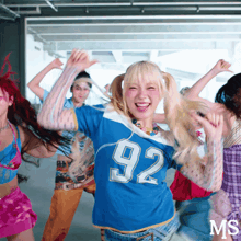 a girl wearing a blue number 92 shirt is dancing