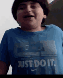 a boy wears a blue shirt that says just do it