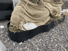 a bag of burlap is sitting on a pile of rocks