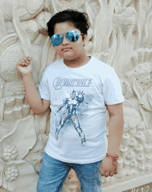 a boy wearing sunglasses and an invincible shirt