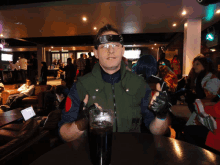 a man sitting at a table with a glass of coke in his hand