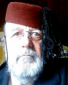 a man with a beard is wearing a red hat and glasses