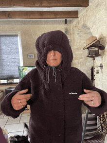 a woman is wearing a columbia jacket with a hood on her head