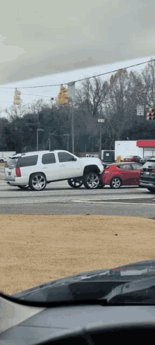 a white suv and a red car are stuck in traffic