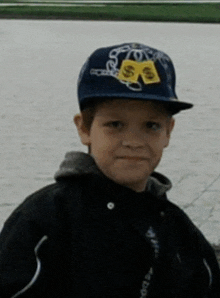 a young boy wearing a hat with a dollar sign on the front