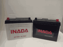 two inada batteries are sitting on a white surface