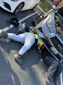 a man is laying under a car with a license plate that says pff089