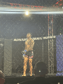 a man stands in a cage with a banner that says advan