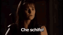 a woman is standing in the dark with the words `` che schifo '' written below her .