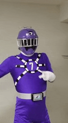 a man in a purple power ranger costume is standing in front of a wall .