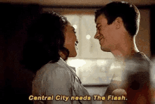 a man and a woman are kissing in a room and the woman is saying `` central city needs the flash '' .