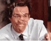 a man with duct tape on his face is smiling and pointing at the camera .