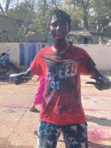 a boy wearing a red shirt that says speed 01 on it